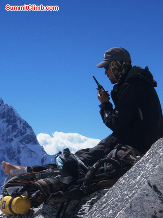 Tenji Sherpa, with bare foot, makes a radio call from camp 1. Photo James Barritt.