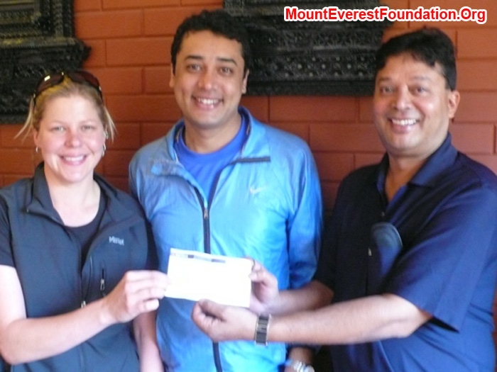 Holly budge presenting a cheque to Mount Everest Foundation directors Murari Sharma and Deha Shrestha. 