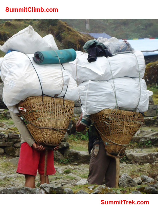 Two porters with big loads in Chutanga. photo by Carla Strong