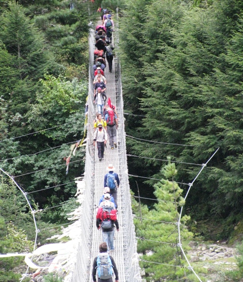 Trekkers on a suspension bridge on the trail to Everest. Photo by Ron and Dee Haberern