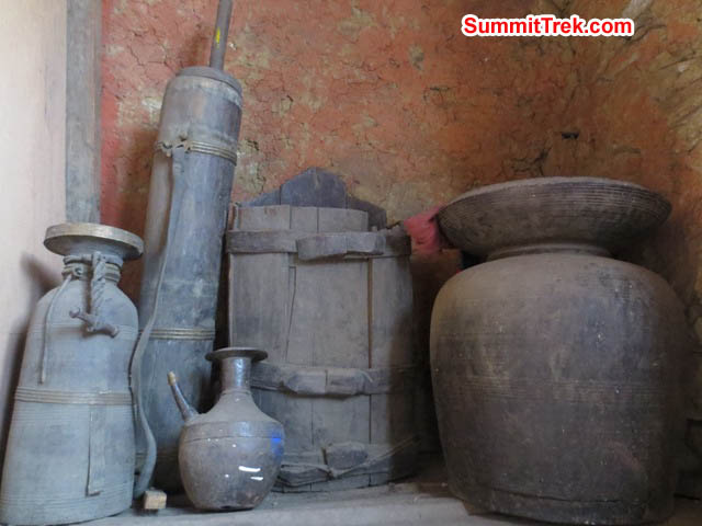 Ancient vessels, butter churns, and chang pots on a shelf inside the Pangboche Monastery. Hannah Rolfson Photo.