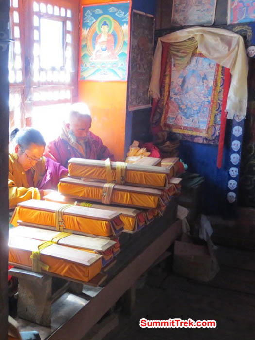 Monks praying for the reincarnation of a local climbing Sherpa who died tragically. They will read all of the prayer books on the table during a week of praying. Photo Hannah Rolfson.
