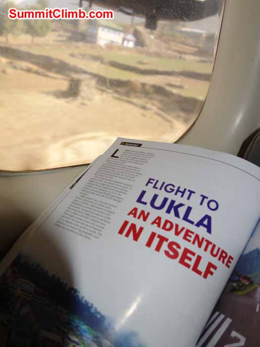 Flight landing at Lukla; onboard magazine open; Lukla village out of the window. Photo David Maidment