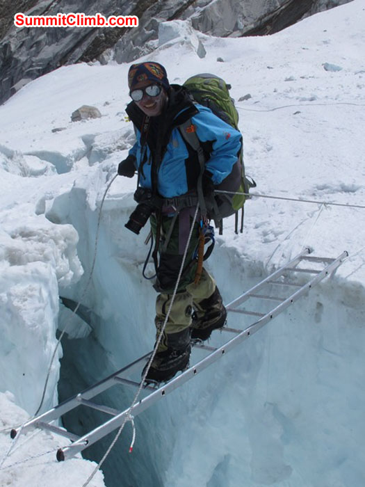 Jangbu Sherpa, 14 time Everest summiter, crosses a ladder in the Khumbu icefall. Monika Witkowska Photo