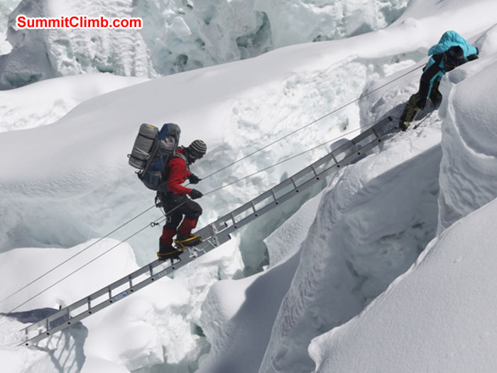 Slavomir Fila climbs a ladder in the Khumbu Icefall while Jangbu Sherpa holds the lines. Monika Witkowska Photo