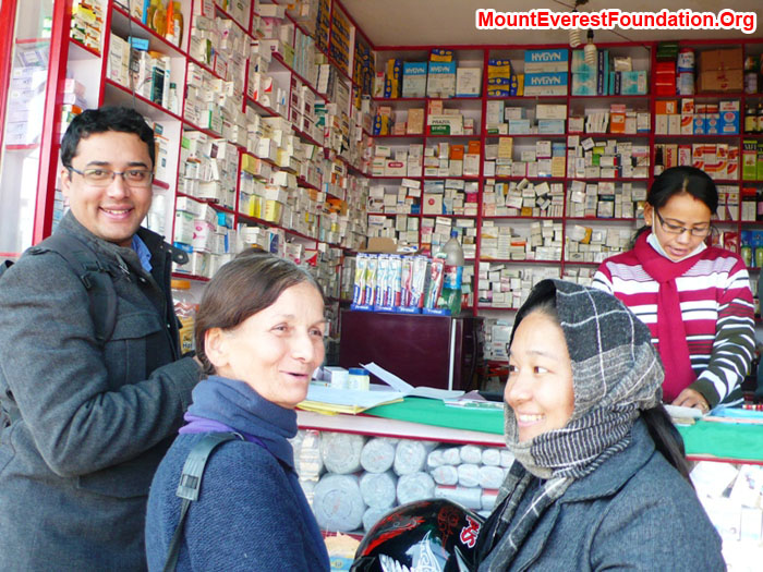 Deha Shrestha from the Mount Everest Foundation with Marie Serys and Yanke Sherpa, filling the prescription for Nimke Sherpa at the chemist's shop.